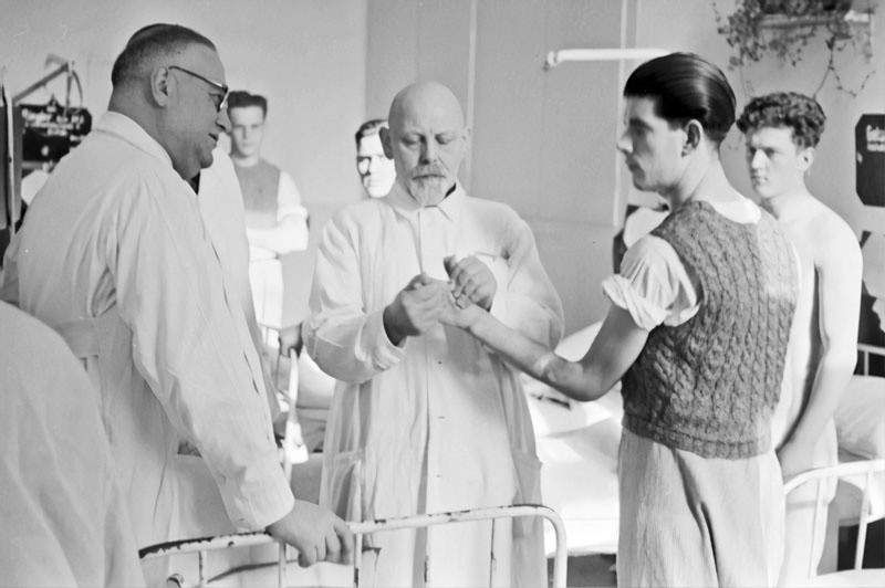 1930s Locum Tenens Career Physician Examining Patient's Hand